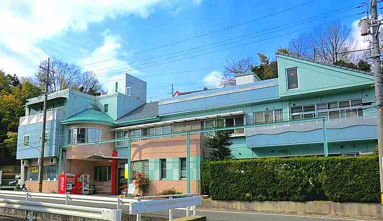 緑色の屋根と外壁が特徴的な介護施設の建物外観。複数階建てで広々とした造りです。